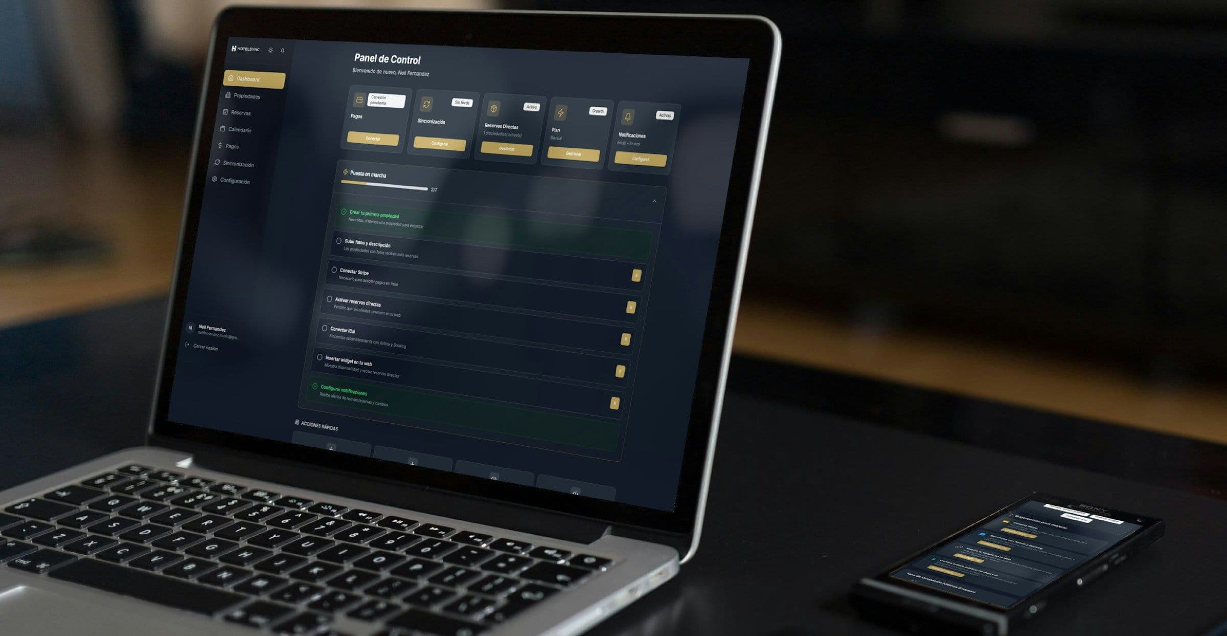 Open laptop and phone displaying the same dark operations dashboard