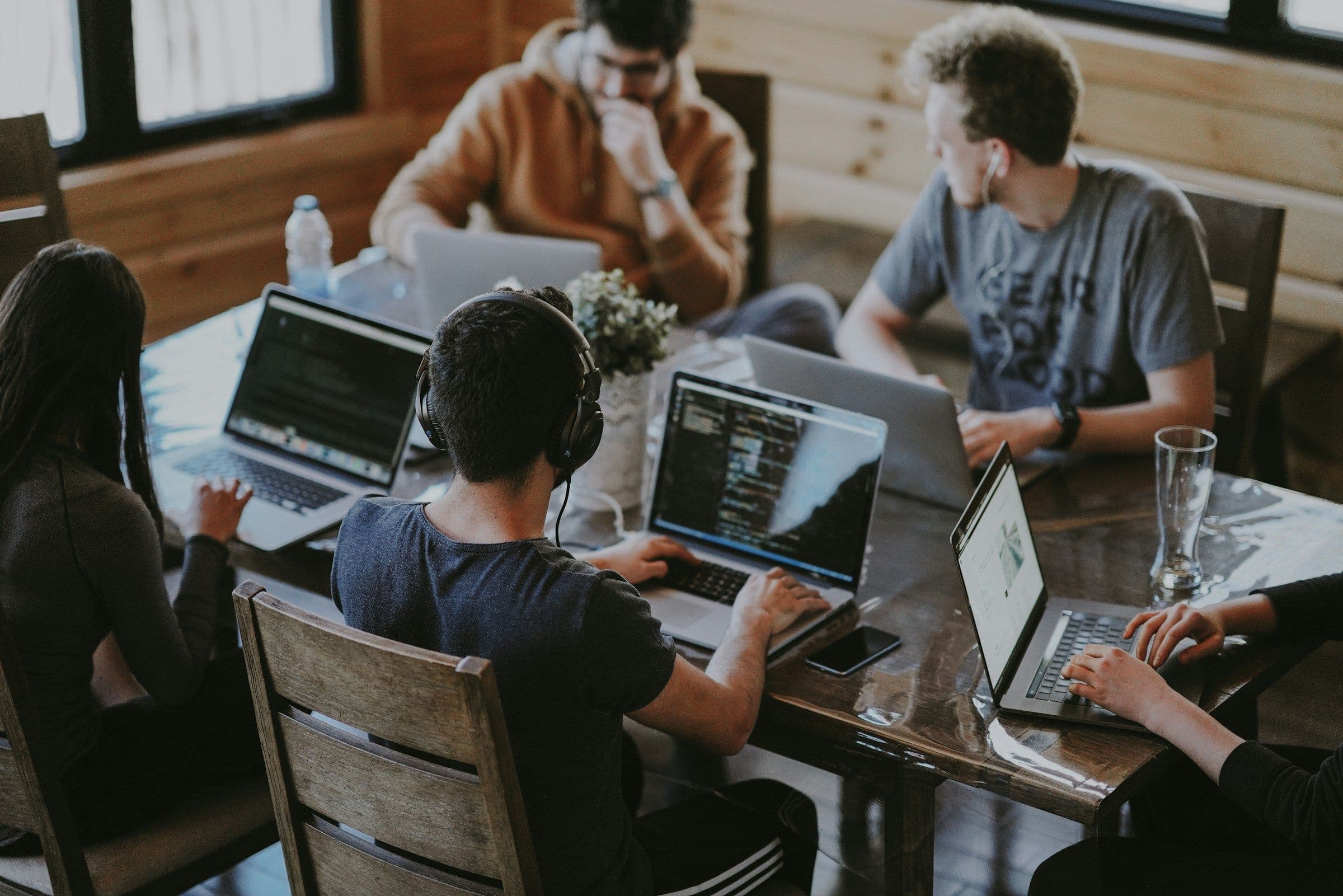 A team collaborating around several laptops