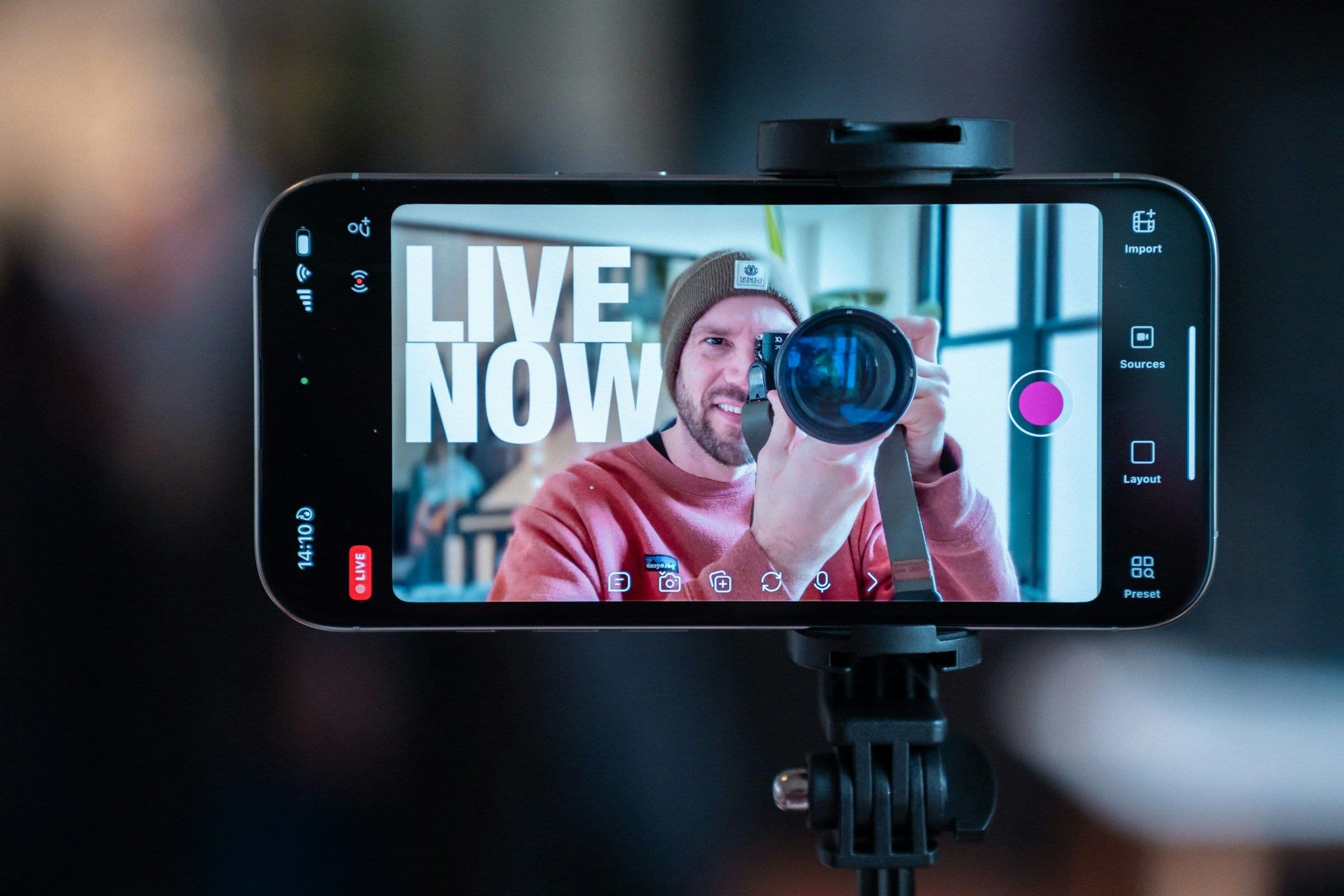 Content creator filming himself with a smartphone and camera