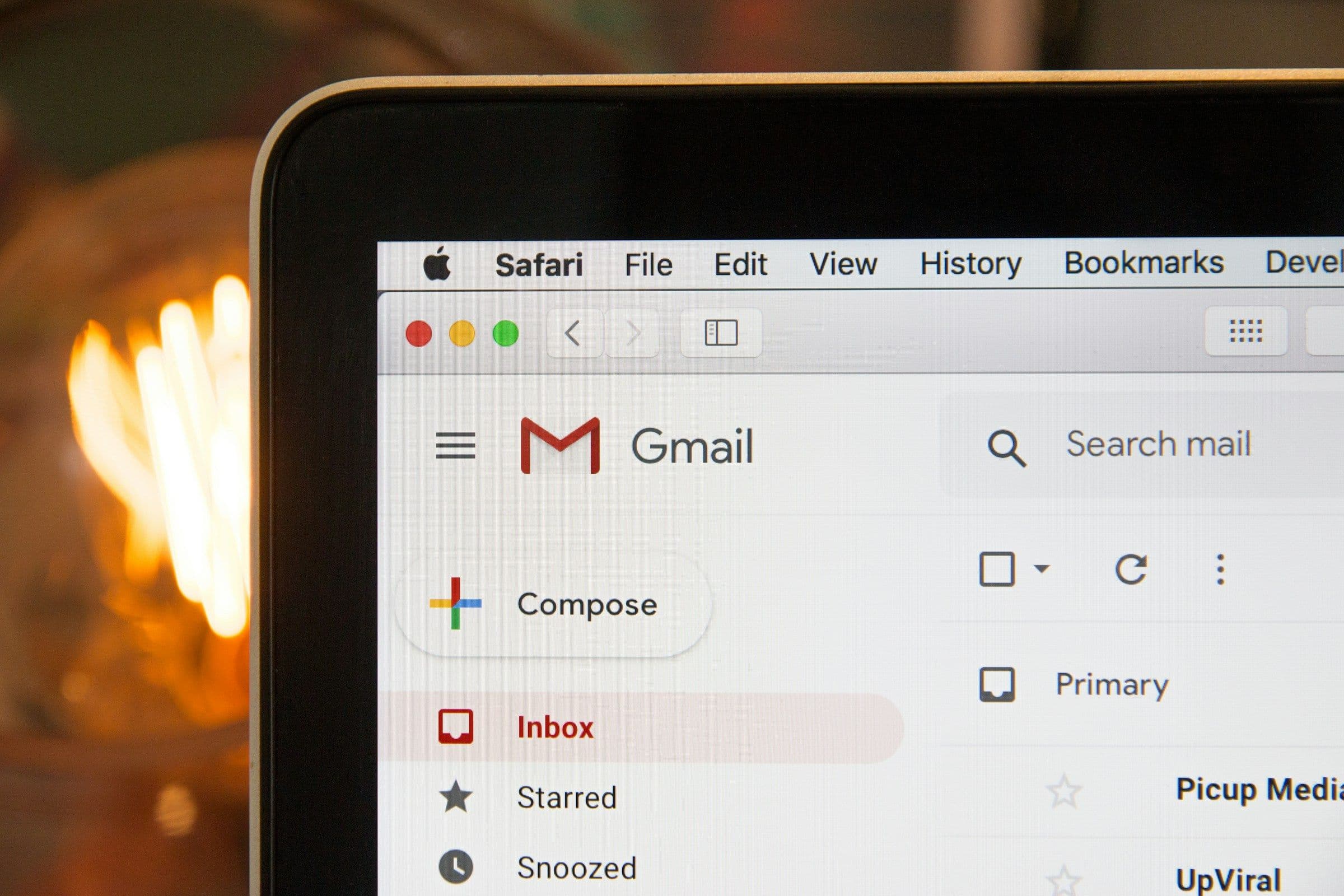 Email inbox open on a laptop beside a workspace