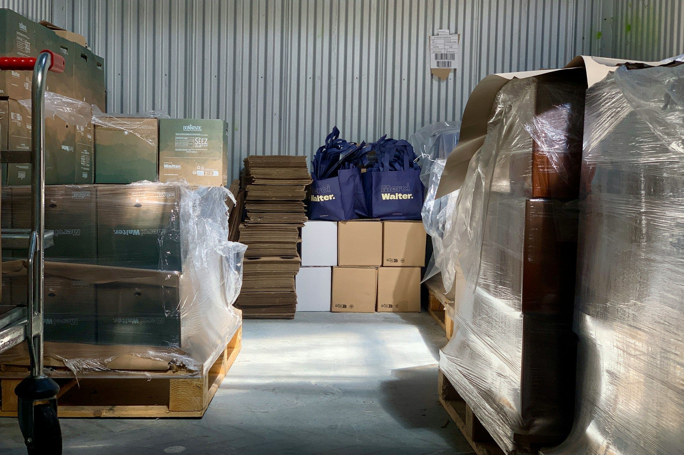 Crowded storage aisle with pallets, cartons, and packing materials