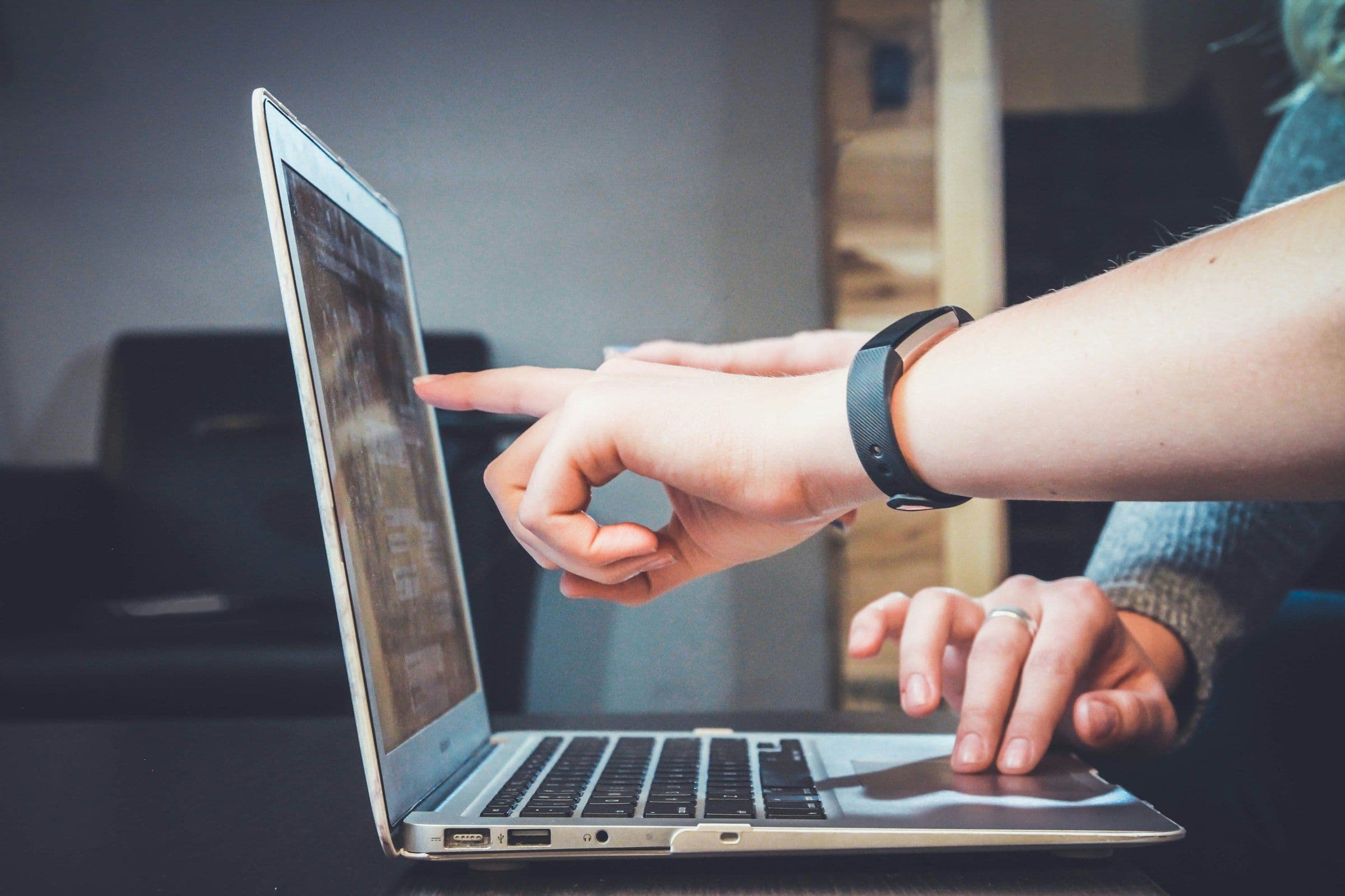 Two localization reviewers checking storefront content and buyer flows on a laptop