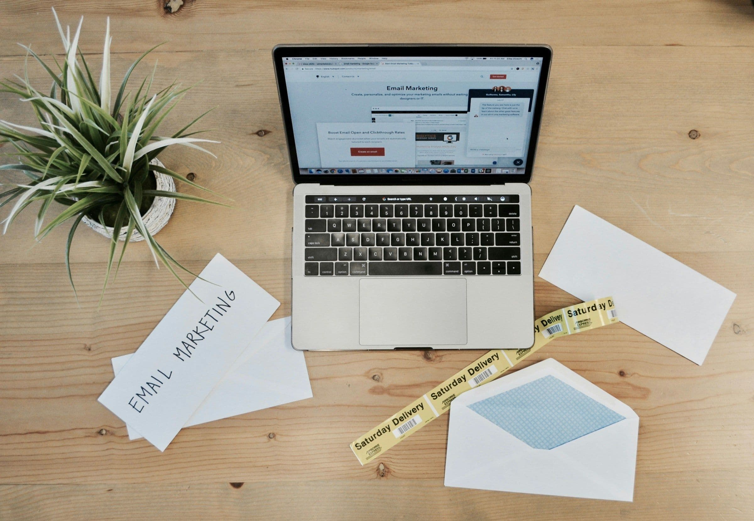 Email marketing workspace with a laptop, envelopes, and planning notes